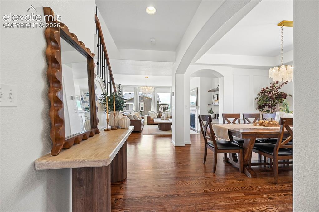 Image 17 of 50: Hardwood flooring, arched doorways, a decorative console table, and an orna