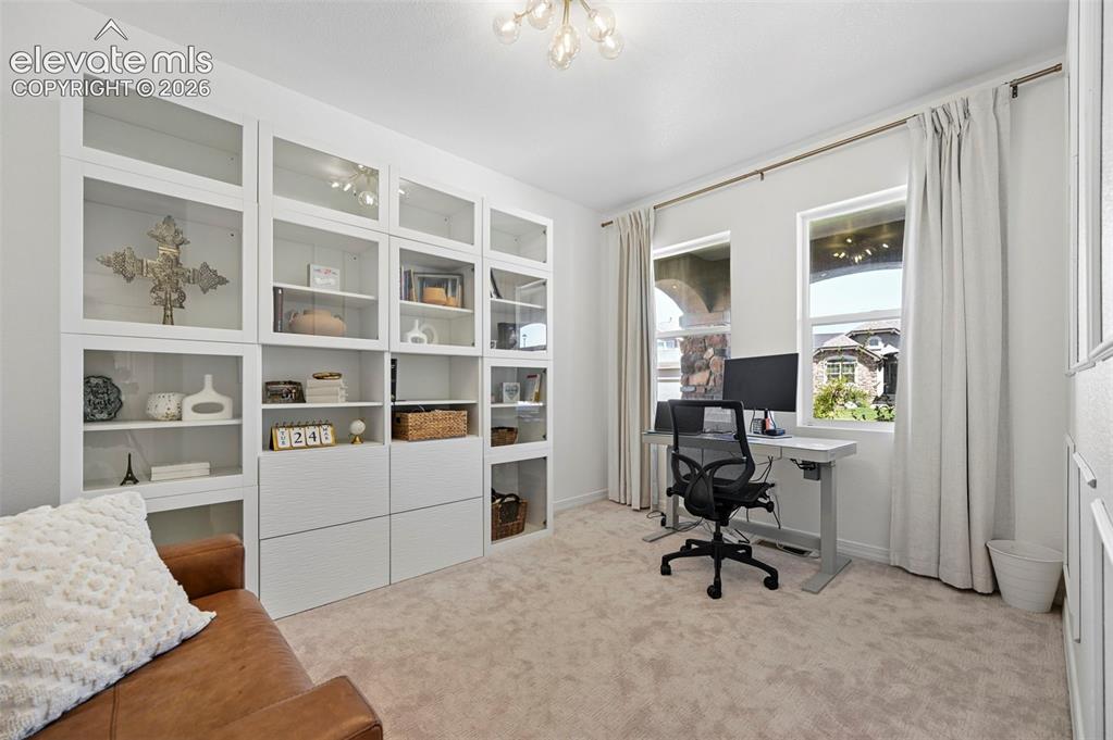 Image 18 of 50: Integrated white built-in cabinetry with glass-front uppers and closed lowe