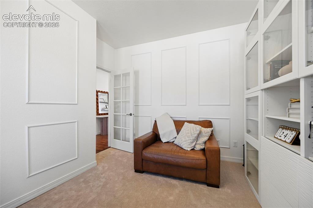 Image 19 of 50: Recessed lighting, light beige carpeting, white wall paneling, built-in she
