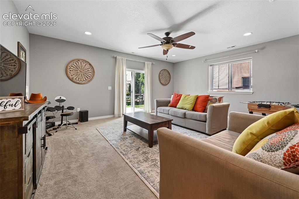 Image 21 of 50: Recessed lighting, ceiling fan, sliding glass door, and carpeted flooring