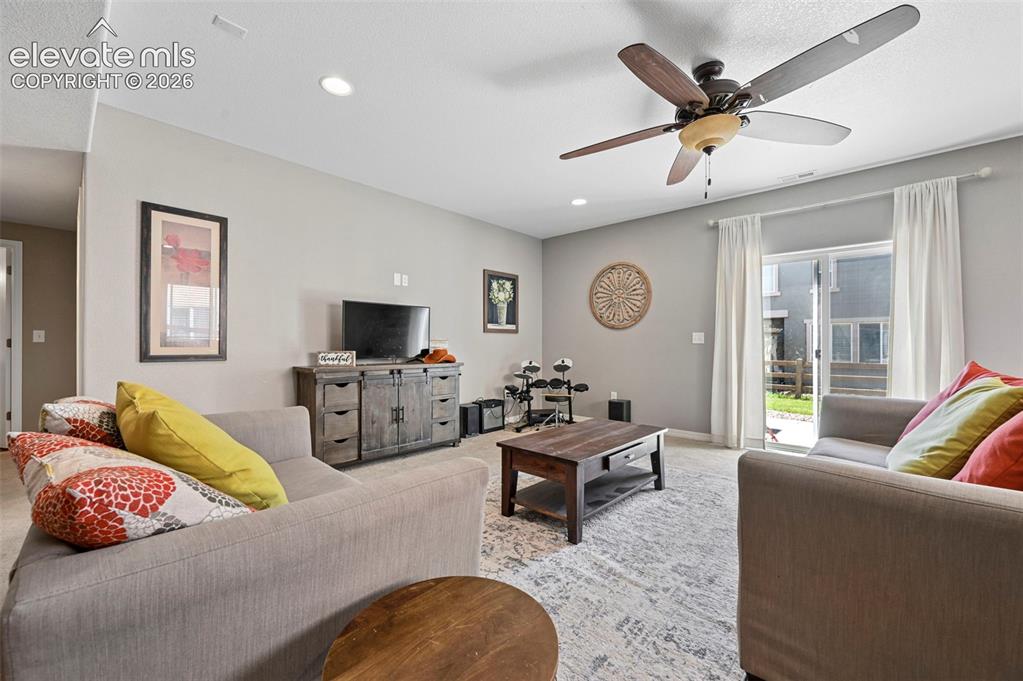 Image 24 of 50: Recessed ceiling lighting, ceiling fan, sliding glass door, and neutral-ton