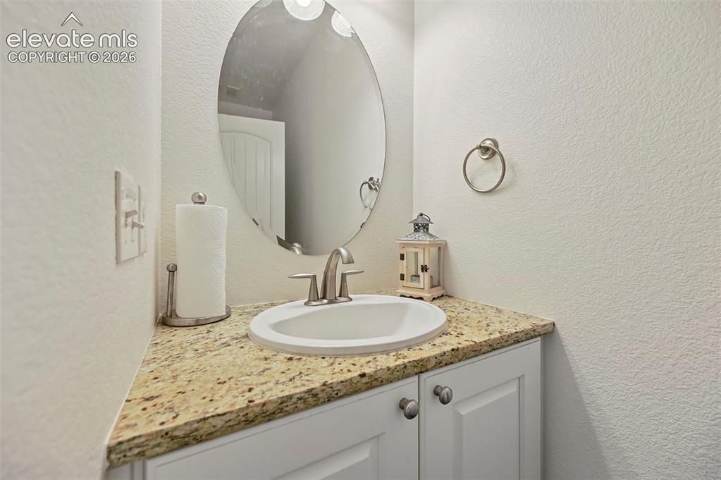 Image 27 of 50: White shaker-style cabinetry with circular silver-toned hardware, light-ton