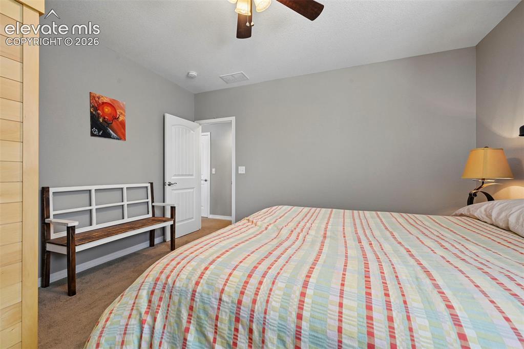 Image 31 of 50: Neutral wall tones, carpeted flooring, and a ceiling fan with integrated li