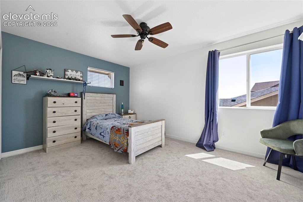 Image 36 of 50: Ceiling fan fixture, wall-to-wall carpeting, window with blinds, and white 