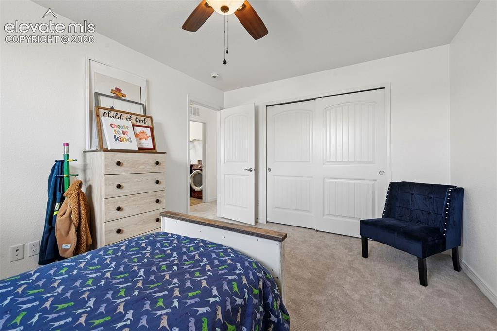 Image 42 of 50: Carpeted flooring complemented by a ceiling fan with integrated lighting, w