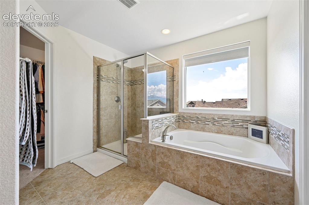 Image 48 of 50: Built-in soaking tub with deck-mounted faucet, tile surround, walk-in showe