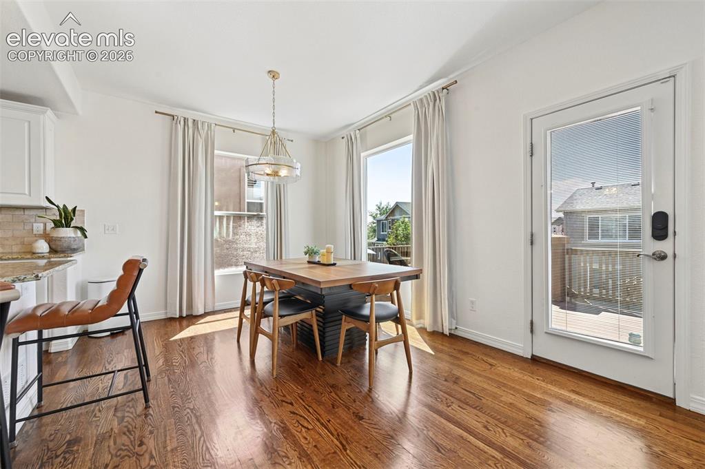 Image 8 of 50: Hardwood flooring, two large windows, white walls, built-in cabinetry, and 