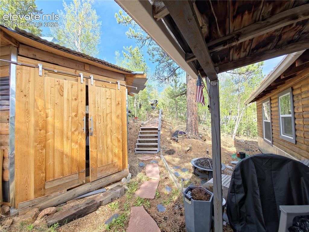 Image 2 of 24: Looking up from front door w/ view of heated shed w/ electric