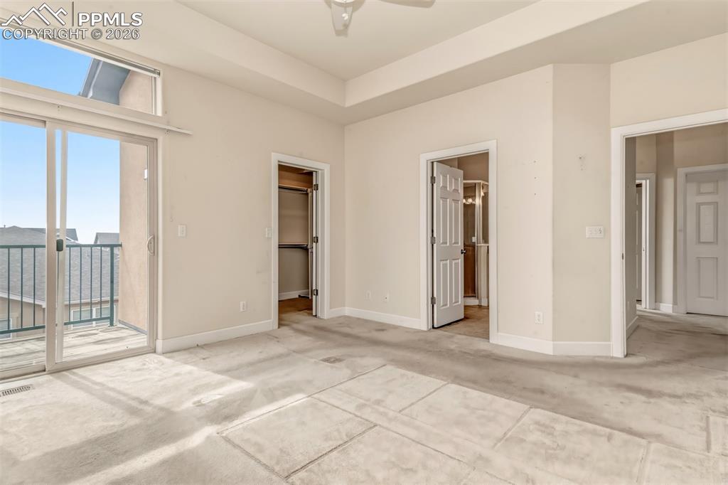 Image 12 of 34: Primary bedroom with walk out deck, walk in closet and en suite bathroom