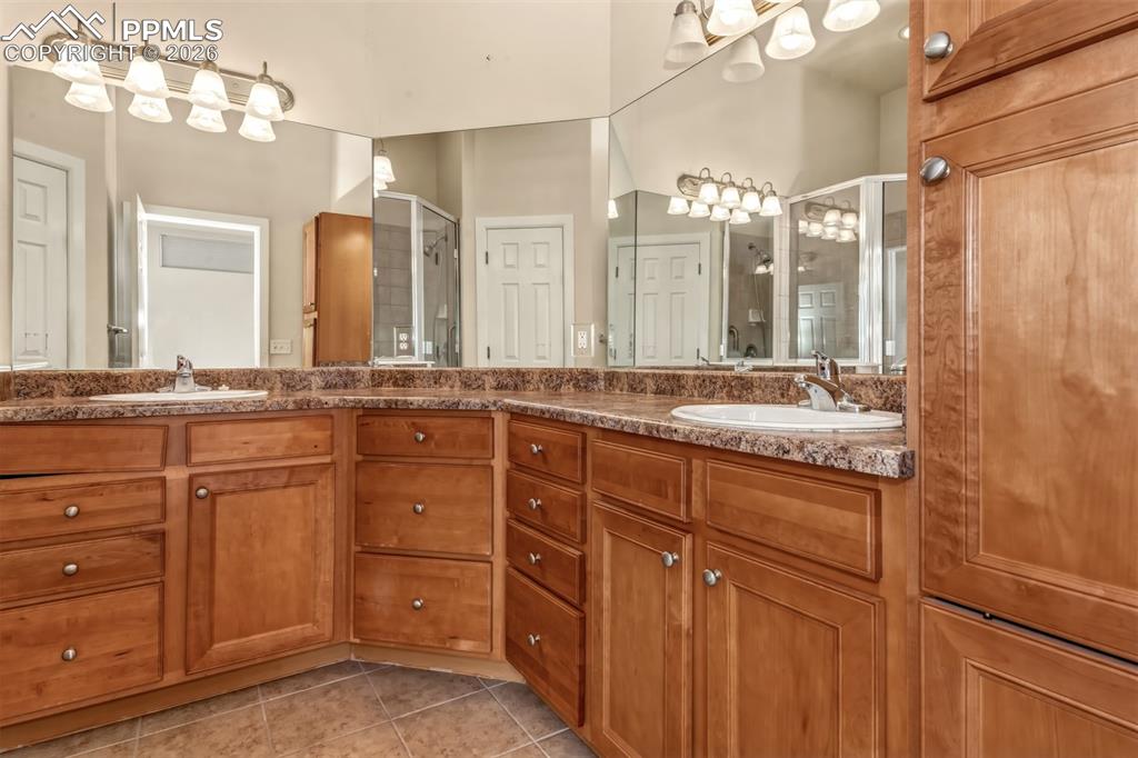 Image 13 of 34: En suite primary bathroom with stand in shower and dual sinks
