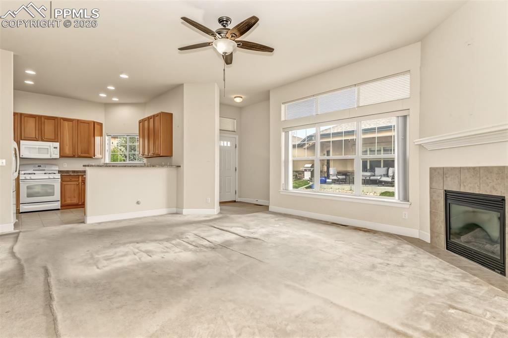 Image 5 of 34: Living room with gas fireplace and plenty of natural light