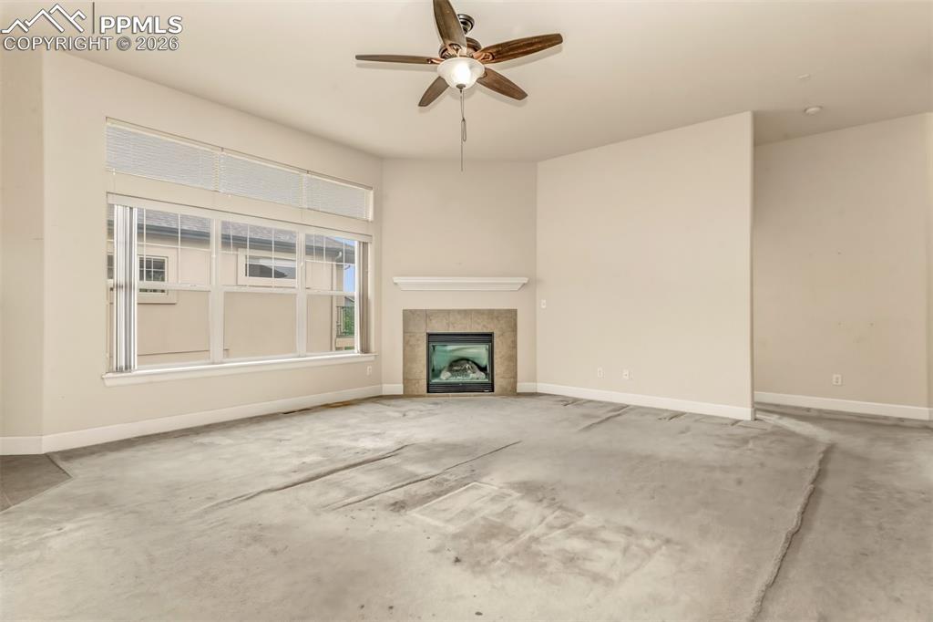 Image 6 of 34: Living room with gas fireplace and plenty of natural light