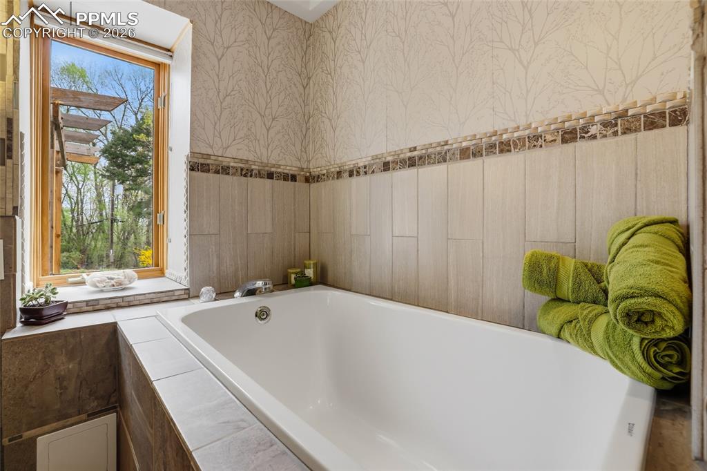 Image 18 of 50: Primary bedroom suite with sitting area on left