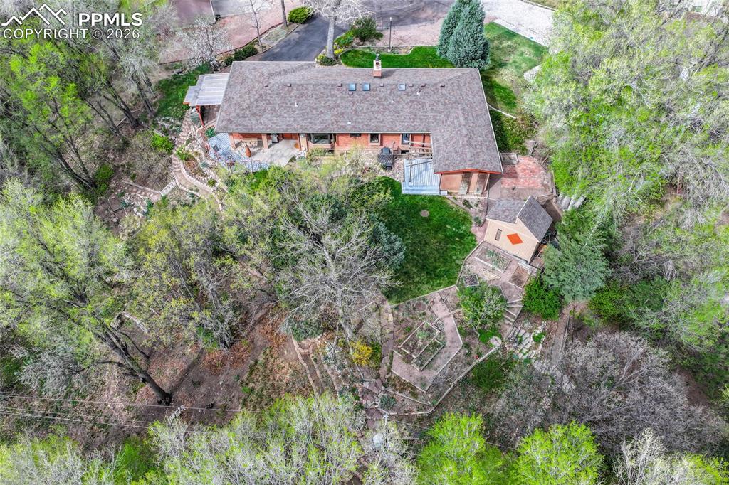 Image 46 of 50: Another view of back yard with garden beds in foreground and garden shed at