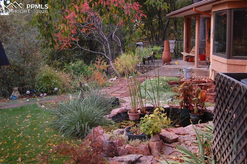 Image 48 of 50: Another view of the terraced garden beds with an off-property seasonal cree