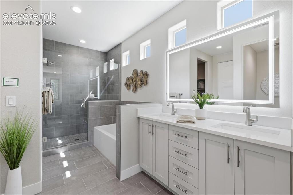 Image 10 of 18: Primary Bathroom with Double Vanities, Quartz Countertops, Heated and Light