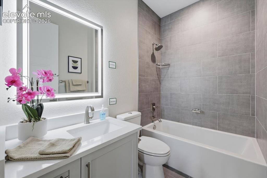 Image 5 of 18: Full Guest Bathroom with Quartz Countertop, Heated Lighted Mirror.