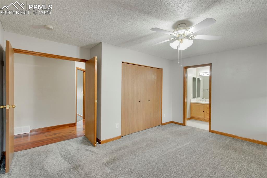 Image 11 of 27: Unfurnished bedroom with carpet flooring, a textured ceiling, a closet, and