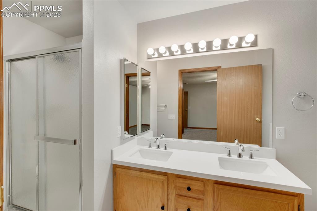 Image 13 of 27: Full bathroom featuring a stall shower and double vanity