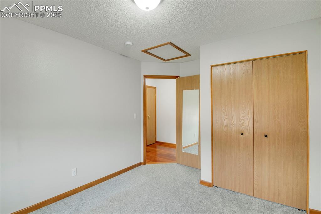 Image 16 of 27: Bedroom with carpet flooring, a closet, and attic access