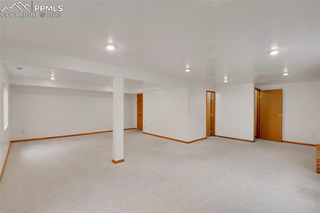 Image 22 of 27: Finished basement with light colored carpet and recessed lighting