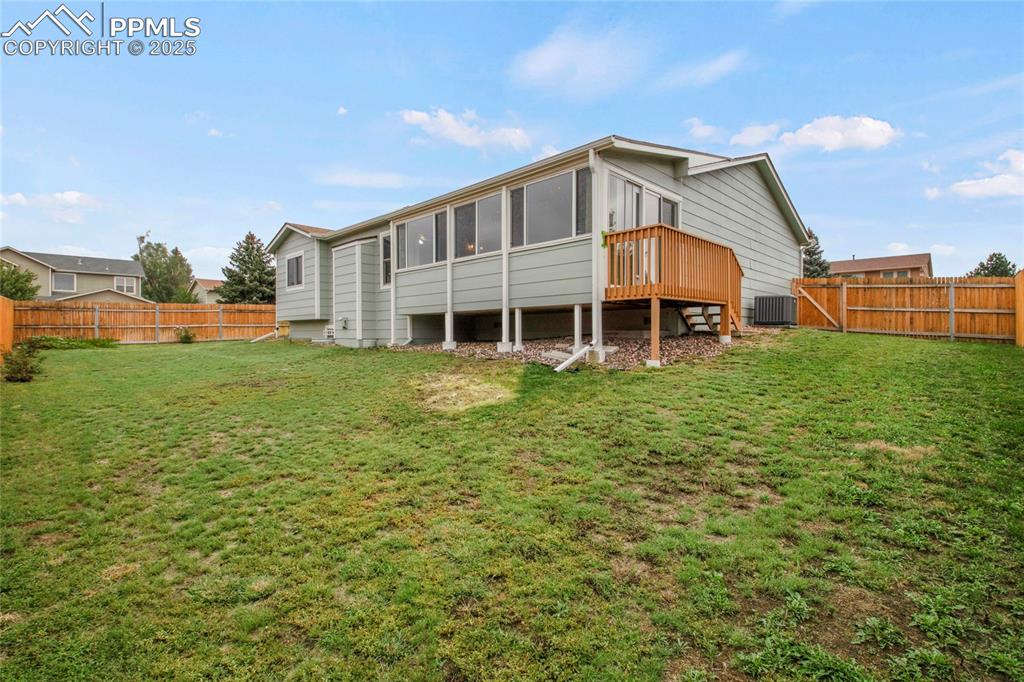 Image 25 of 27: Rear view of property featuring a sunroom, and a wooden deck