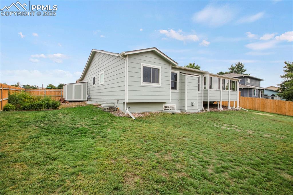 Image 27 of 27: Back of property with a fenced backyard