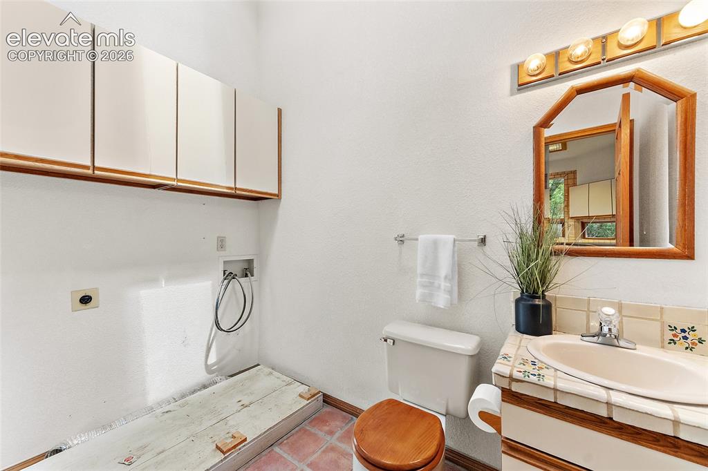 Image 21 of 49: 1/2 bath located near kitchen and dining room