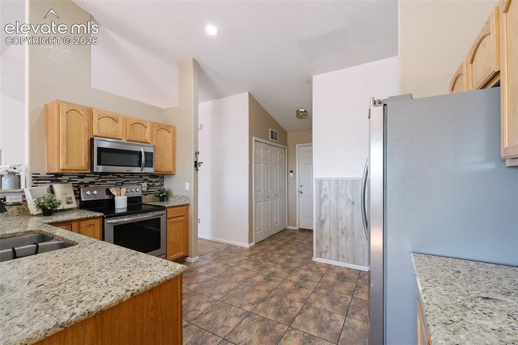 Image 18 of 50: Open and functional kitchen featuring granite countertops, stainless steel 