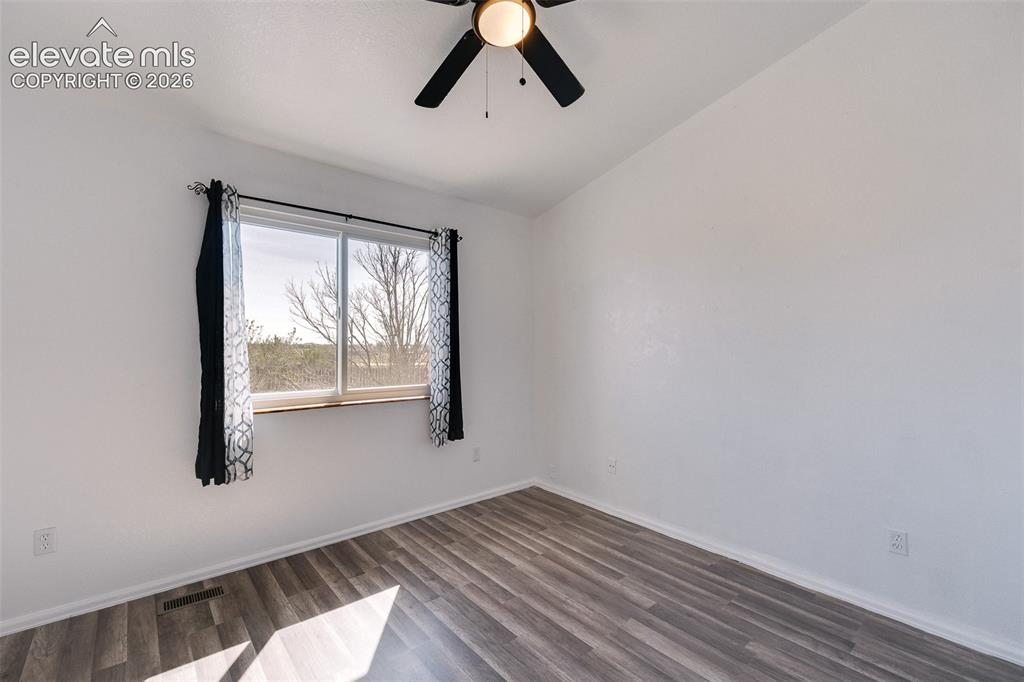 Image 24 of 50: Vaulted Main Level Bedroom #2 has a lighted ceiling fan and luxury vinyl pl