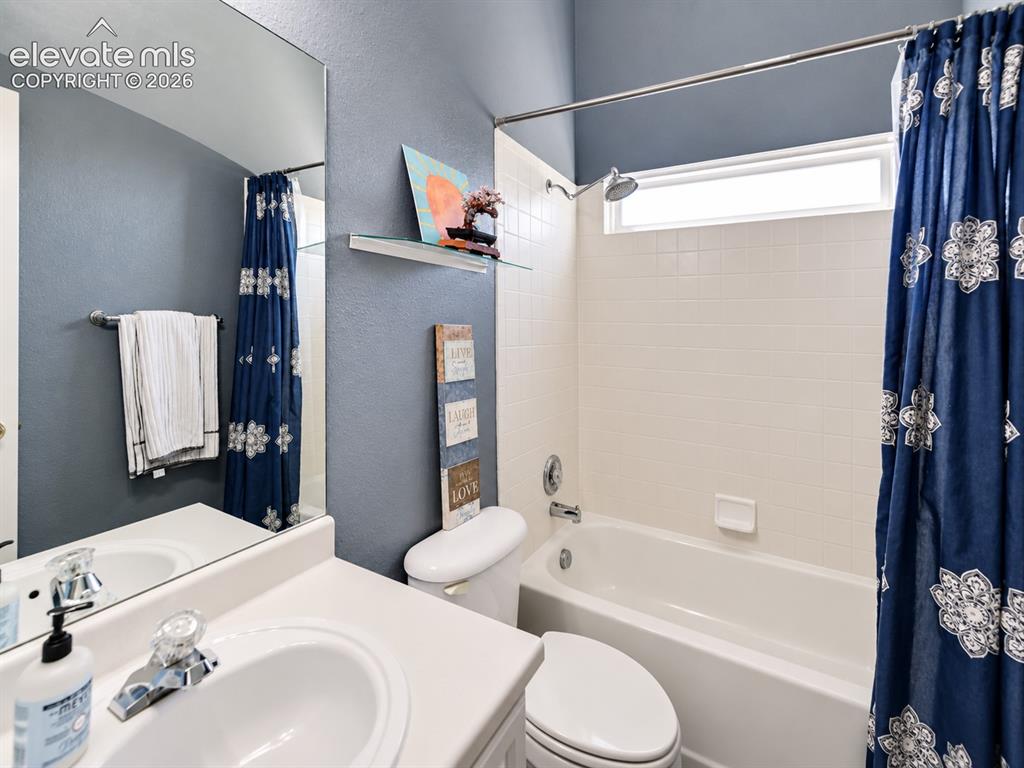 Image 26 of 50: Main level Full Bathroom with vanity, mirror, and tiled tub/shower.