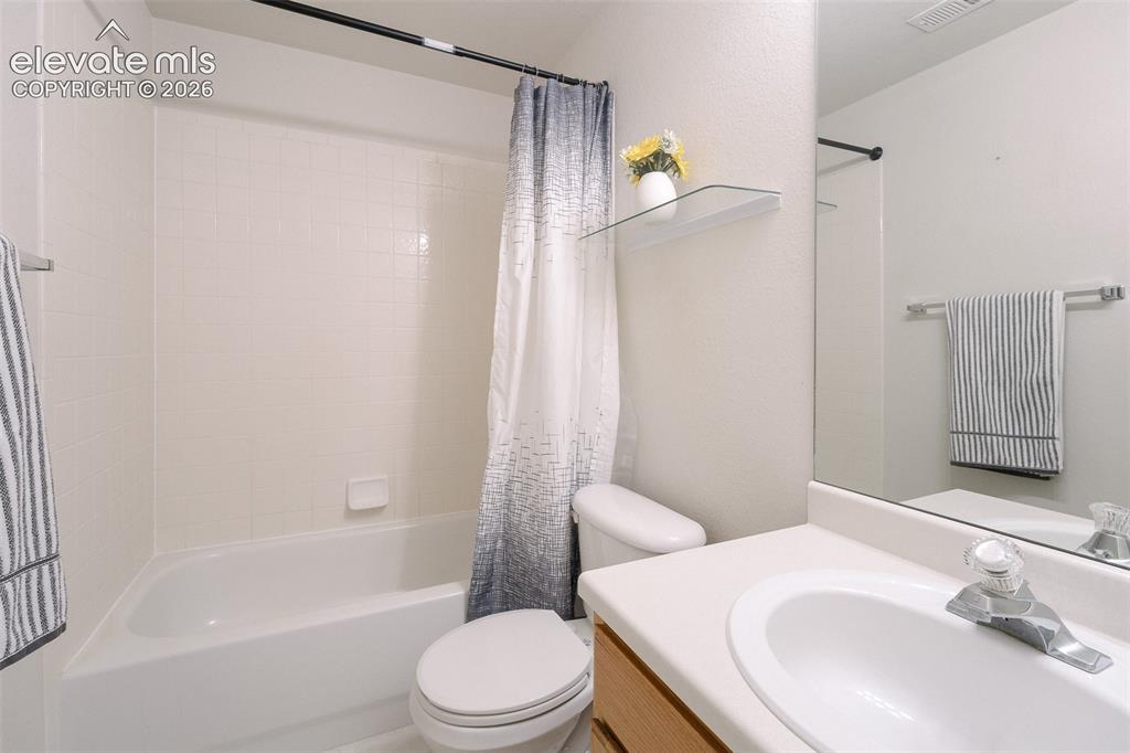 Image 35 of 50: The Basement Bathroom features a vanity, mirror, and tiled tub/shower.