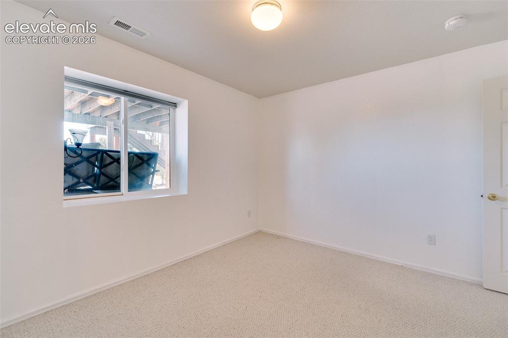 Image 36 of 50: Basement Bedroom #4 has neutral carpet.