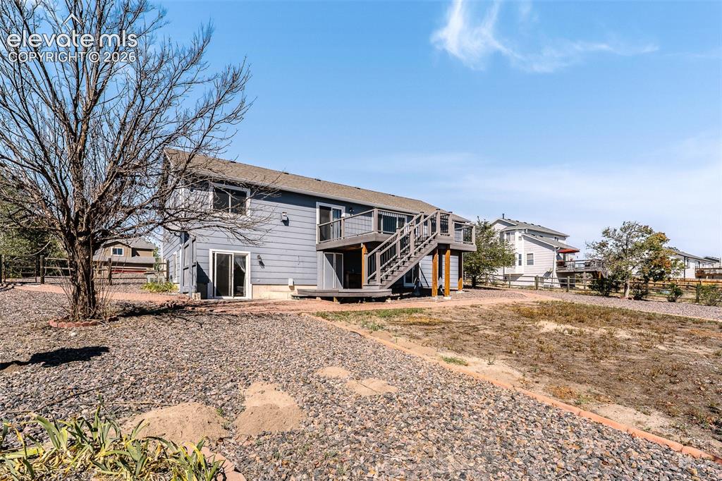 Image 41 of 50: Rear view of home and fenced backyard.