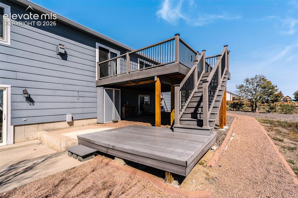 Image 43 of 50: Backyard deck and lower level patio.