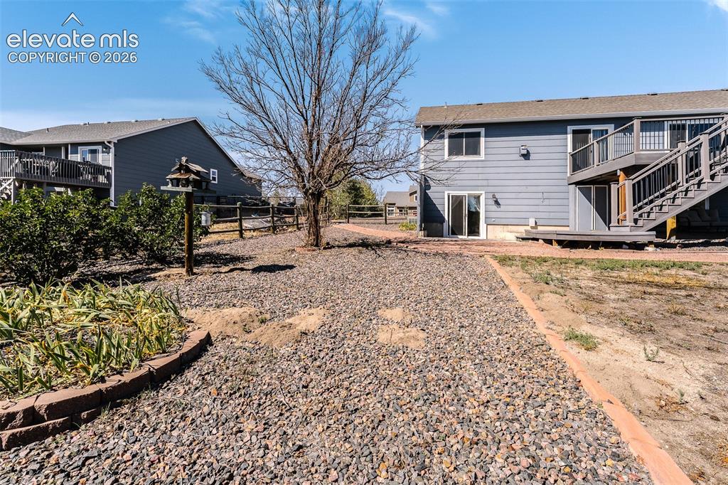Image 44 of 50: Low maintenance xeriscaped yard with mature trees, walkways, planters, and