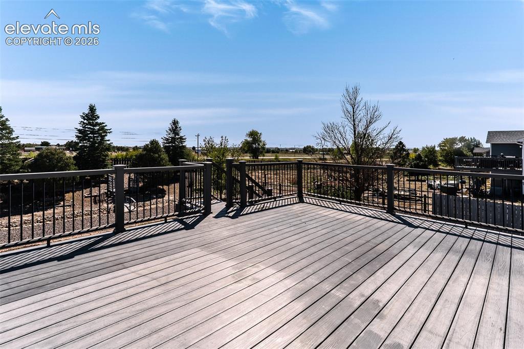 Image 5 of 50: Large composite backyard deck with stairs to the backyard.