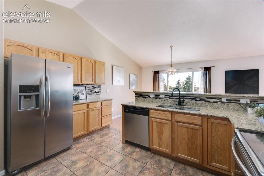 Image 7 of 50: The Kitchen features tile flooring, wood cabinetry with granite countertops