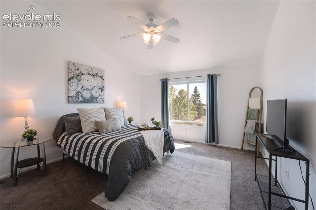 Image 8 of 50: The vaulted Primary Bedroom is a serene retreat with a lighted ceiling fan,