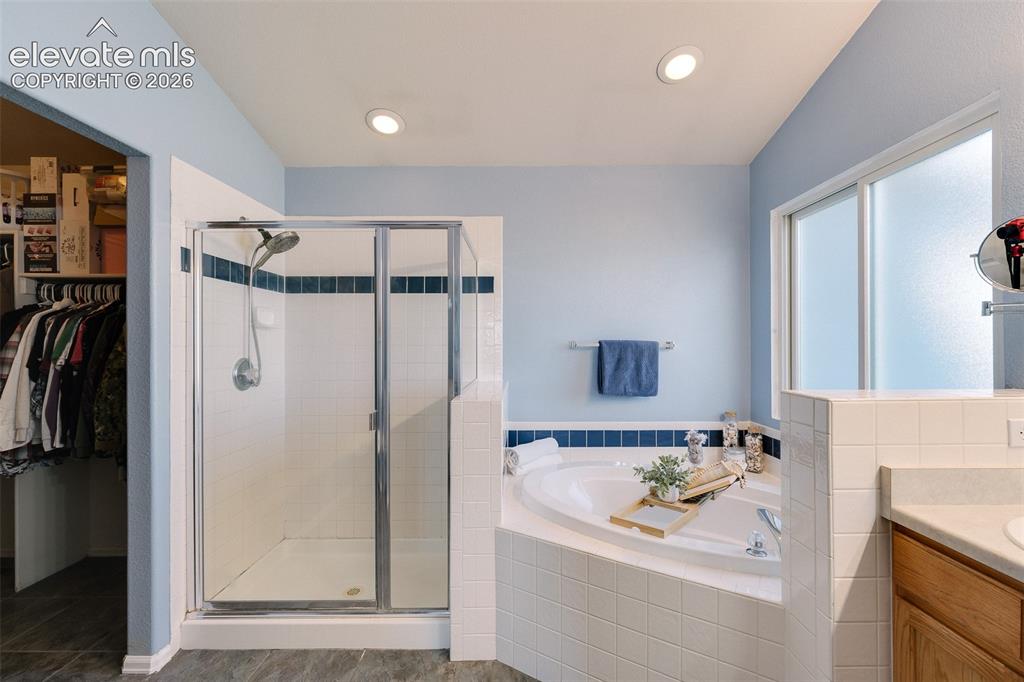 Image 9 of 50: The Primary Bathroom offers a dual sink vanity, soaking tub, and separate t