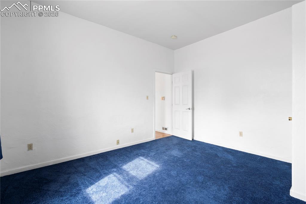 Image 11 of 21: Spare room featuring baseboards and carpet flooring