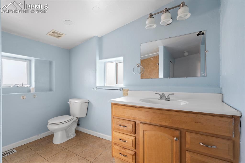 Image 15 of 21: Bathroom with vanity, light tile patterned floors, and a shower