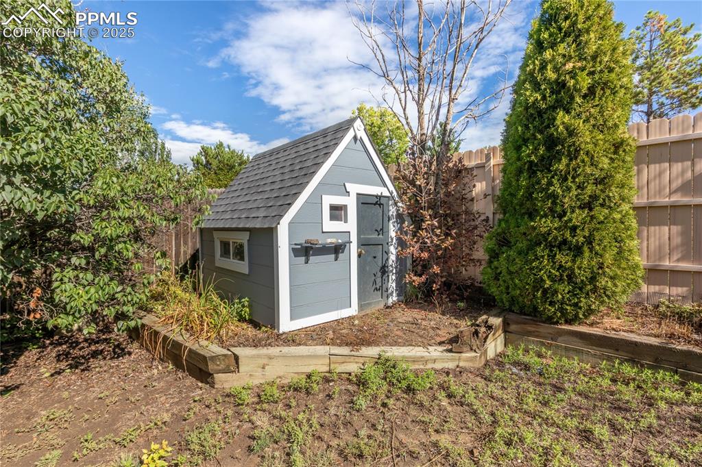 Image 32 of 33: Small playhouse in backyard