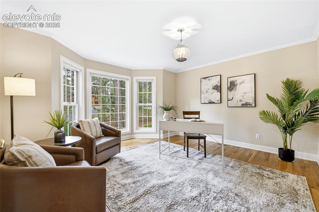 Image 6 of 50: To the left, a main level office with Bay window, crown molding and French
