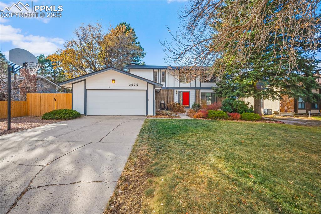 Caption: Beautifully landscaped front yard with mature trees and RV parking. 