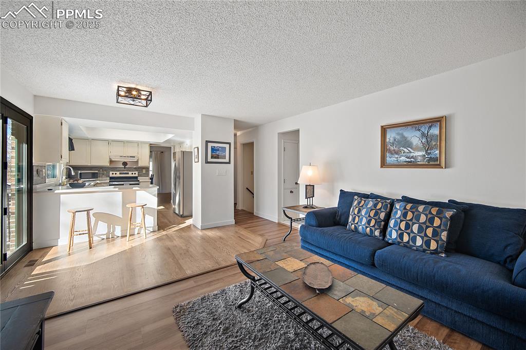 Image 15 of 49: Family room is open to the kitchen and walks out to large wood deck.