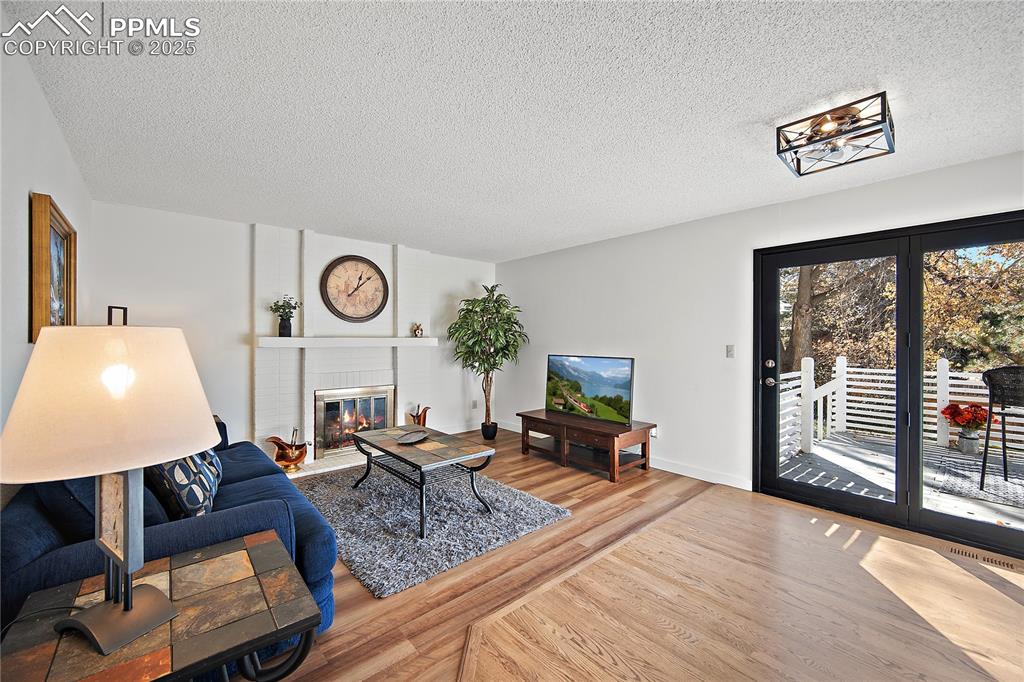 Image 16 of 49: Family room with new laminate flooring, wood brungin frireplace and walk ou