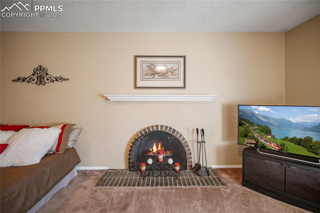 Image 22 of 49: Wood burning fireplace with sitting area.