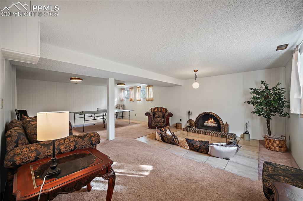 Image 33 of 49: Wood burning fireplace and sunken floor for cozy gathering.