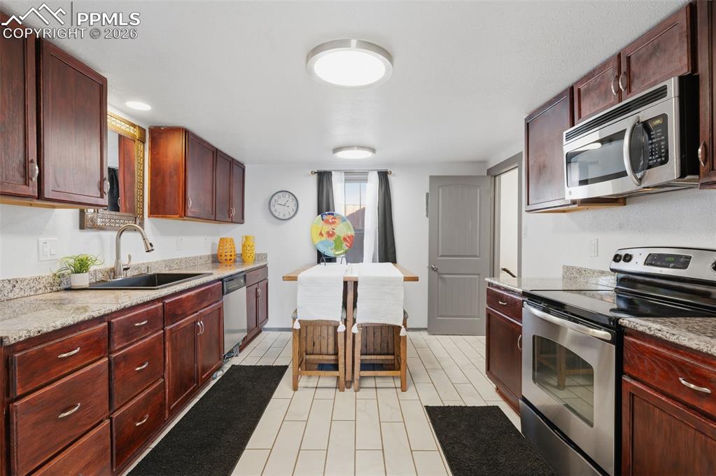 Image 12 of 48: This kitchen has granite countertops, stained chocolate cabinets with new L